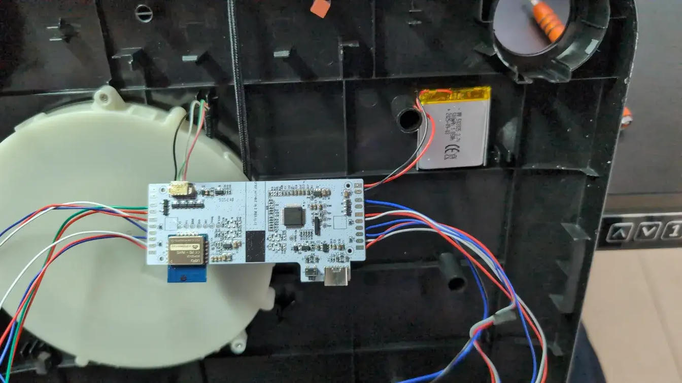 Close-up of the Hume Pod battery showing its connector terminals labeled BAT+ and BAT- on the PCB.