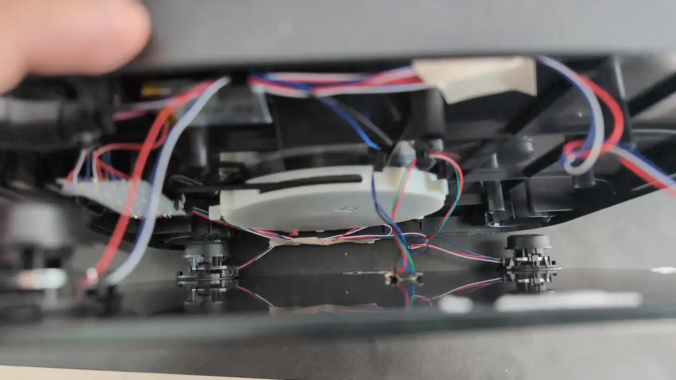 Internal view of the Hume Pod after opening: one white shell housing the retractable cable connecting to the handlebar, an LED panel connected to the processing board, four strain gauges connected to the PCB, the battery, and the cables linking to the tempered glass.